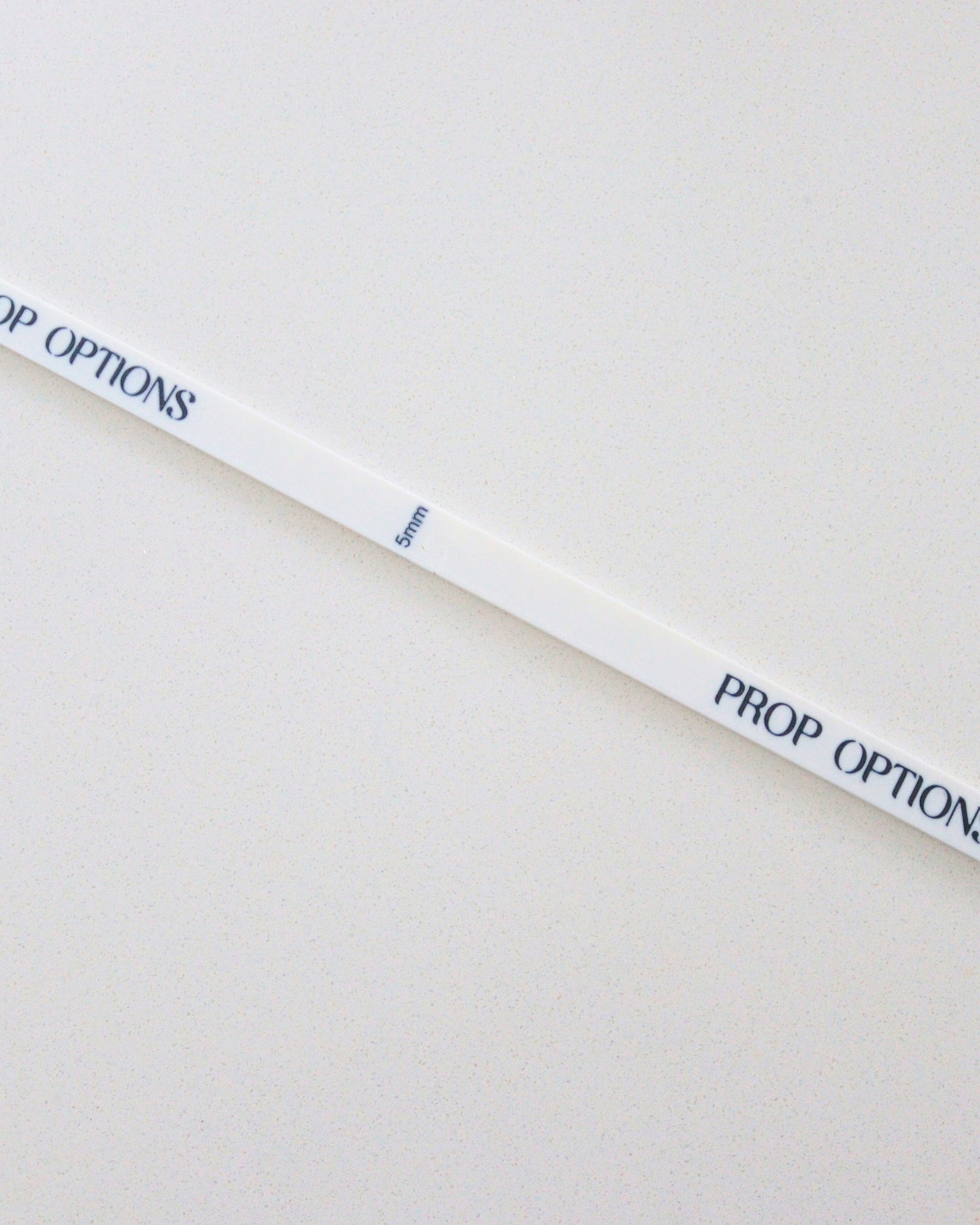 White ruler with 'PROP OPTIONS' text on a beige background