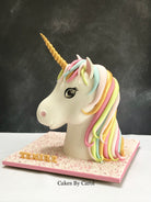 Unicorn cake with colorful mane on a stand against a dark background